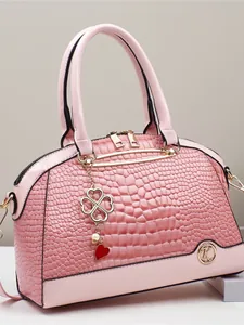 Sac à main rose à motif crocodile avec garniture dorée et doubles anses sur support
