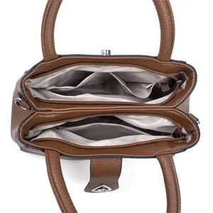 Internal view of brown leather handbag with two zipped compartments and light gray lining