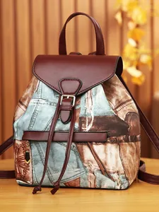 Vintage two-tone faux leather and denim backpack with gold hardware and flap closure