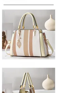 Detail der gestreiften Handtasche mit Goldverschluss Blattanhänger und Ledergriff