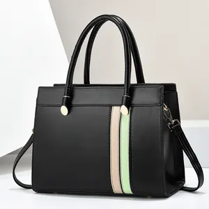 Detail of contrast color leather tote bag with gold hardware and pink green stripes