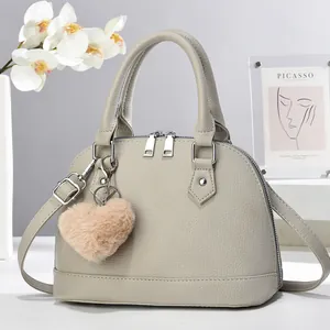 Close-up of light grey litchi grain shell bag with heart plush charm and silver hardware