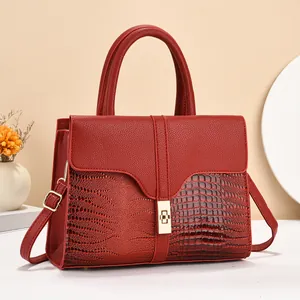 Detail of red crocodile texture tote with golden twist lock and luxury faux leather