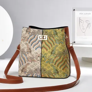 Detail of jacquard bucket bag showing ethnic pattern stitching and gold turn-lock closure