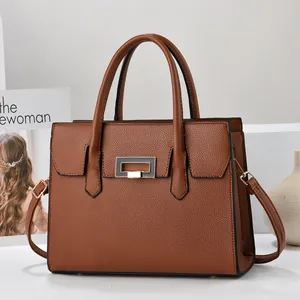 Detail shot of caramel lychee grain leather tote bag with metal twist lock and handles