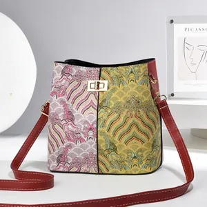 Detail of jacquard bucket bag showing ethnic cloud patterns and gold twist lock