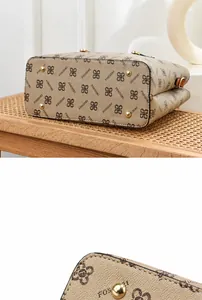 Detail view of the beige tote bag base featuring four protective gold metal feet studs