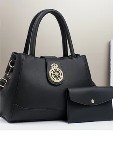 Elegante borsa a mano in pelle nera con stemma corona dorata e pochette coordinata