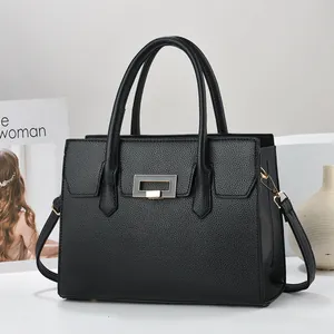 Close-up of black lychee grain leather tote bag with elegant gold metal buckle detail