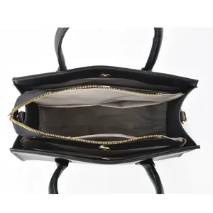 Top view of black pebbled leather tote showing triple compartments and grey lining