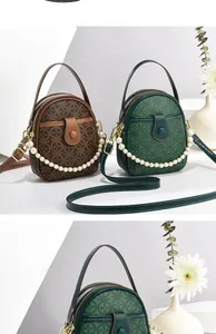 Detail of vintage round bag with pearl chain handle and classic monogram pattern