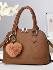 Caramel pebble leather shell handbag with heart plush charm and adjustable shoulder strap