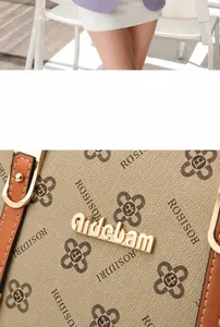 Close-up of contrast color tote bag with grain texture, floral prints and gold logo