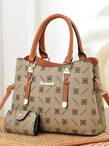 Fashionable monogram tote bag set with matching wallet and golden hardware on wicker background