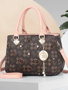 Brown checkered handbag with pink leather straps and a crescent moon pendant