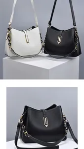 Détail d'un sac à main en cuir synthétique grainé avec fermoir doré et bandoulière