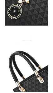 Close-up of litchi leather handbag with gold hardware and pearl flower pendant charm