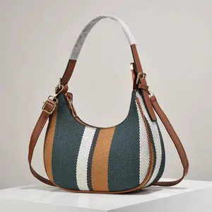 Minimalist striped canvas hobo bag with brown leather trim and golden metal hardware