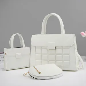 Detailed macro view of 3-piece white tote set with embossed patterns and gold chain