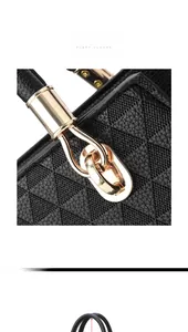 Detail of black leather handbag with geometric triangle pattern and gold metal hardware