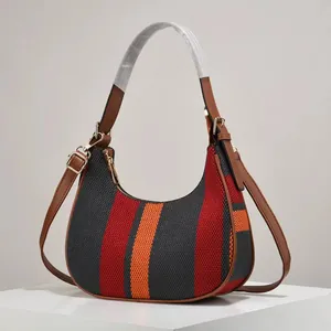 Detail of hobo bag with red orange black stripes and brown faux leather handle