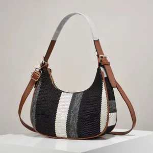 Close-up of hobo bag showing striped woven fabric texture and brown leather strap detail