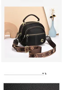 Detail of black lychee grain leather handbag with jacquard strap and gold K-logo