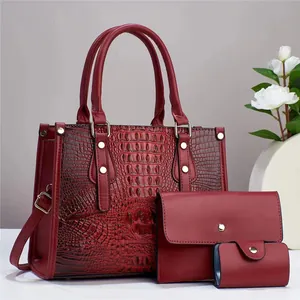 Dettaglio del set borsa rossa texture coccodrillo con portafogli coordinati chic