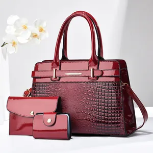 Three-piece burgundy patent leather tote set with crocodile texture and gold hardware