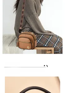 Close-up of a brown leather crossbody bag with vintage floral wide strap and gold logo