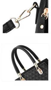 Close-up of polished gold-tone hardware and textured black leather handle on the tote bag
