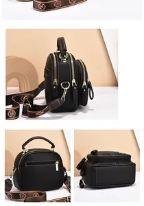 Detail of black pebbled leather handbag with multiple gold zippers and wide logo strap