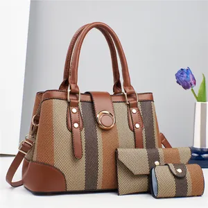 Detailed view of 3-piece brown canvas handbag set with gold buckles and striped texture
