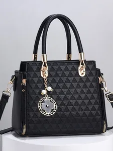 Schicke schwarze Tragetasche mit geometrischer Textur und goldener Hardware auf Podest