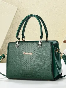 Dark green crocodile texture tote bag with gold hardware and top handle shown in studio