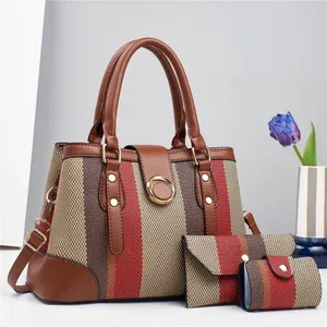 Detailed macro view of the 3-piece striped handbag set with golden metal rings and studs