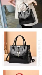 Close-up of black crocodile pattern tote bag with cat charm and sleek leather texture