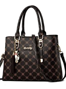 Deep-toned monogram tote bag with gold logo, cat charm, and adjustable shoulder strap