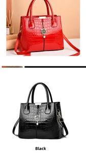 Detail of red and black crocodile pattern patent leather bags with metal cat charms