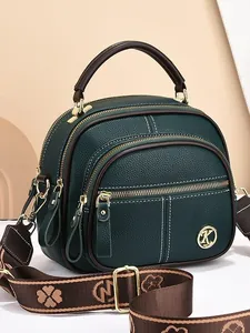 Dark green pebbled leather shoulder bag with multi-layer zippers and floral strap