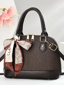 Braune Muschelhandtasche mit vertikaler Textur und Seidenschal-Accessoire im Studio-Setup