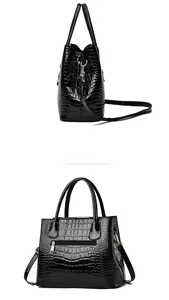 Detail of black crocodile texture glossy handbag showing side profile and rear zipper pocket