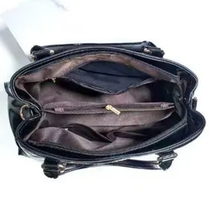 Internal view of the handbag showing multiple compartments and golden hardware details