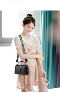 Chic black litchi leather pillow bag shown with stylish geometric patterned shoulder strap