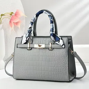 Détail du sac cabas gris motif crocodile avec garniture dorée et élégant foulard en soie