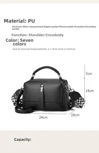 Detailed view of black Boston bag with pebbled leather texture and wide patterned strap