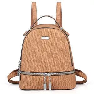 Detail of brown woven texture fabric and silver zipper hardware on the travel backpack