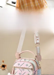 Detail of floral printed crossbody bag with gradient pink tones and wide fabric strap
