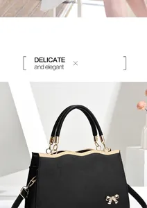 Detail showing crosshatch leather texture, golden bow ornament and wavy metal trim on handbag