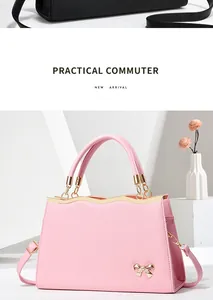 Detailed view of pink commuter bag featuring golden wave trim and a metal bow accent